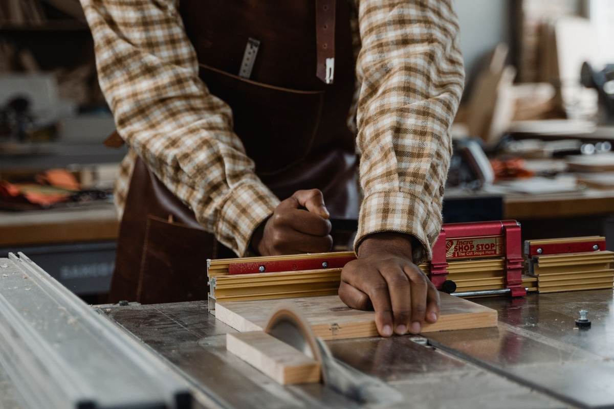 Homme utilisant une scie pour couper du bois dans un atelier