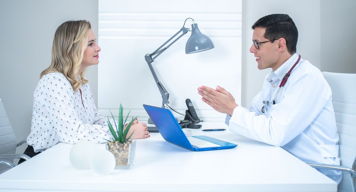 Médecin et patiente en consultation avec ordinateur portable